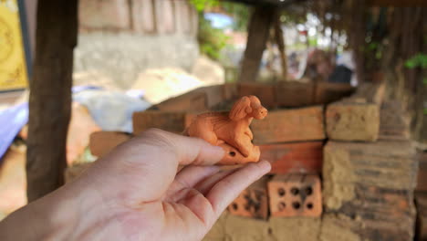 close-up of a handcrafted clay flute in the shape of a dog, made in thanh ha, vietnam