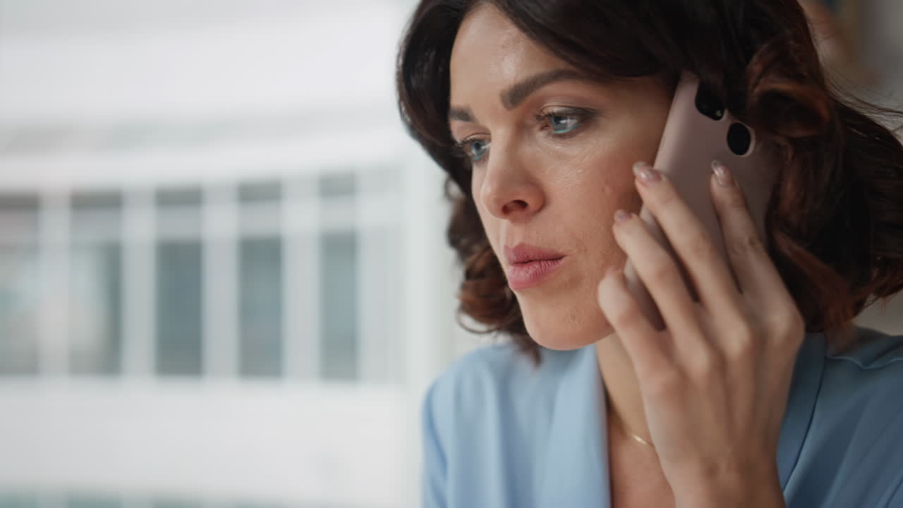 Serious office worker calling smartphone call at company office closeup worried