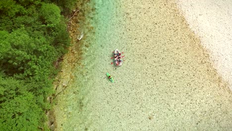 aerial view of a group of people doing rafting turquoise and transparent water.