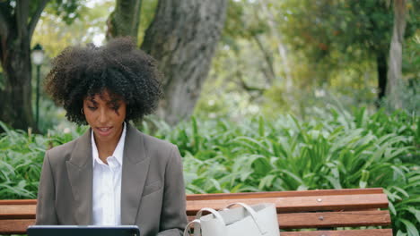 Chica-Sentada-En-Un-Banco-Con-Portátil-De-Cerca.-Mujer-Sonriente-Charlando-Usando-Un-Cuaderno-Moderno