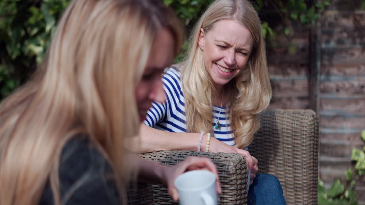 Two women enjoying coffee in a garden