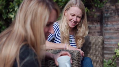 two women enjoying coffee in a garden