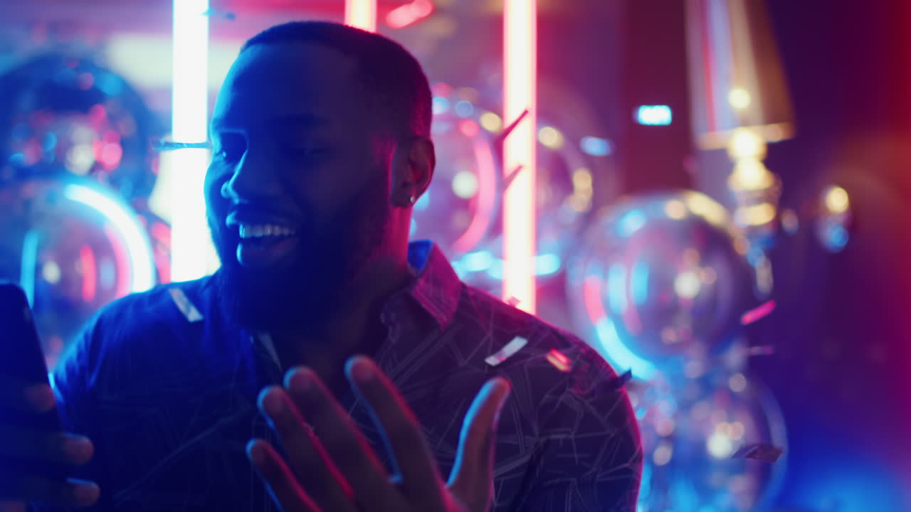 hombre africano emocionado leyendo un mensaje en el club. hombre afro hablando en una fiesta