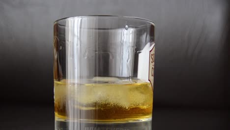 wiskey rotating in the glass with ice cubes