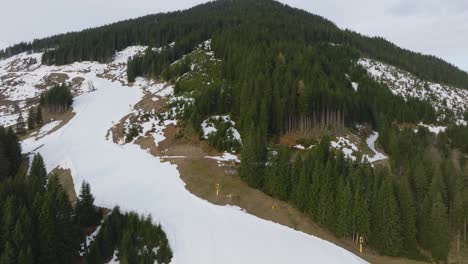 Toma-Aérea-De-La-Estación-De-Esquí-De-Saalbach-hinterglemm-En-Austria-Con-Nieve-Derritiéndose,-Que-Muestra-La-Transición-Del-Invierno-A-La-Primavera,-Vista-Ascendente