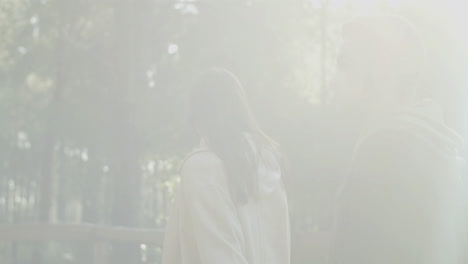 young couple walking in park enjoying sunny day