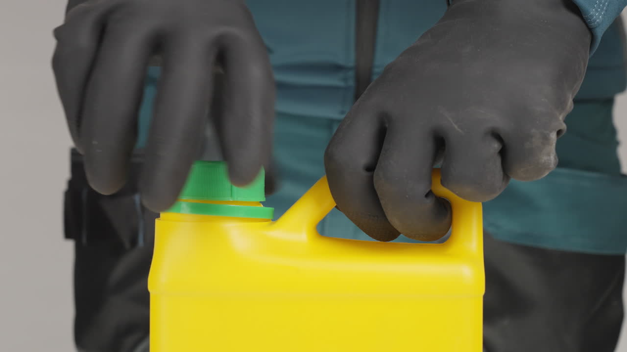persona abriendo un recipiente de plástico amarillo con guantes