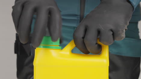 person opening a yellow plastic container with gloves