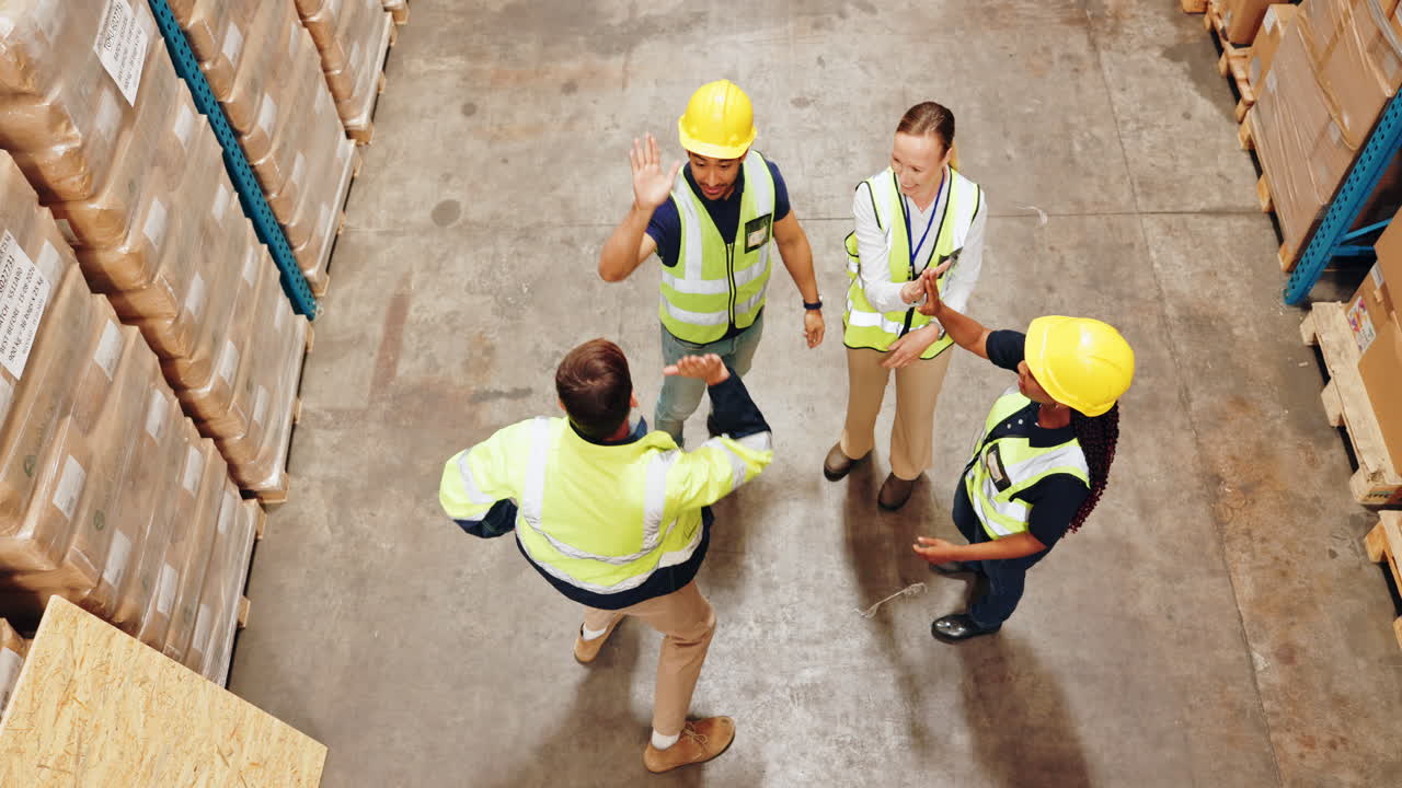 Team of warehouse workers celebrating in a warehouse