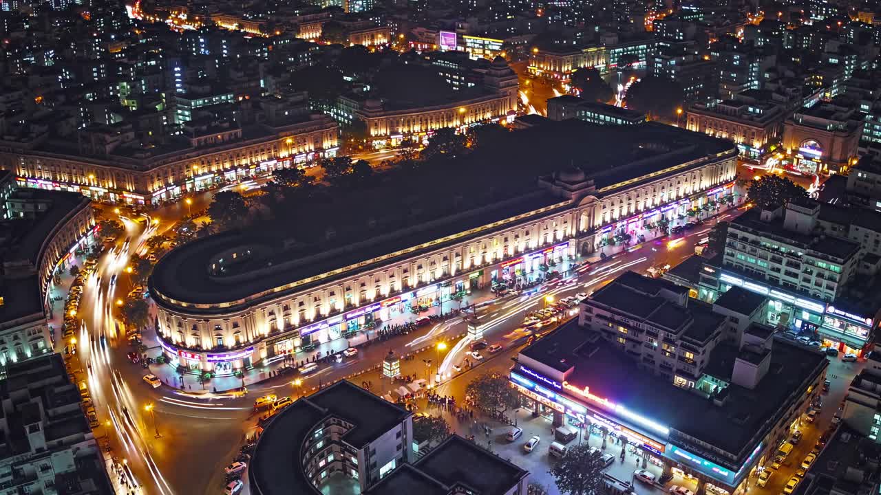 Aerial view of a bustling city at night, showcasing vibrant lights and busy streets