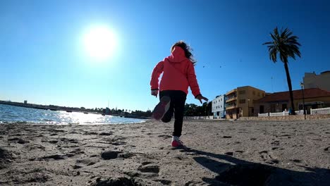 niña corre en la playa en cámara lenta