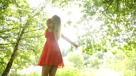 beautiful teen twirling in the sunlight under the trees