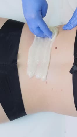 woman getting body waxing treatment
