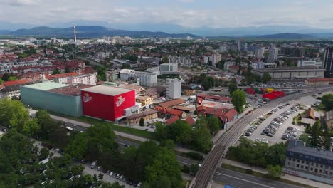 aerial left orbit reveals the historic union brewery complex in ljubljana, slovenia, showcasing its iconic red-brick buildings and landmark brewery structures in the heart of the city.