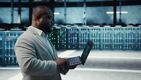vertical video manager overseeing server room, walking with laptop, troubleshooting hardware