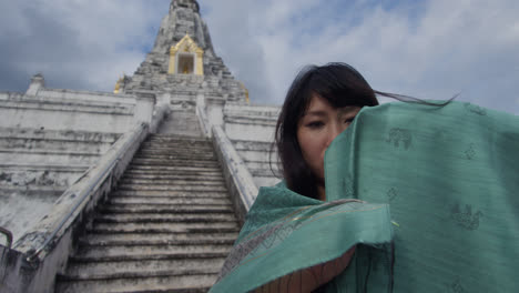 Una-Mujer-Esconde-Su-Rostro-Con-Un-Velo-En-El-Templo-Budista-Wat-Arun,-El-Templo-Del-Amanecer,-Que-Se-Encuentra-A-Orillas-Del-Río-Chao-Phraya.