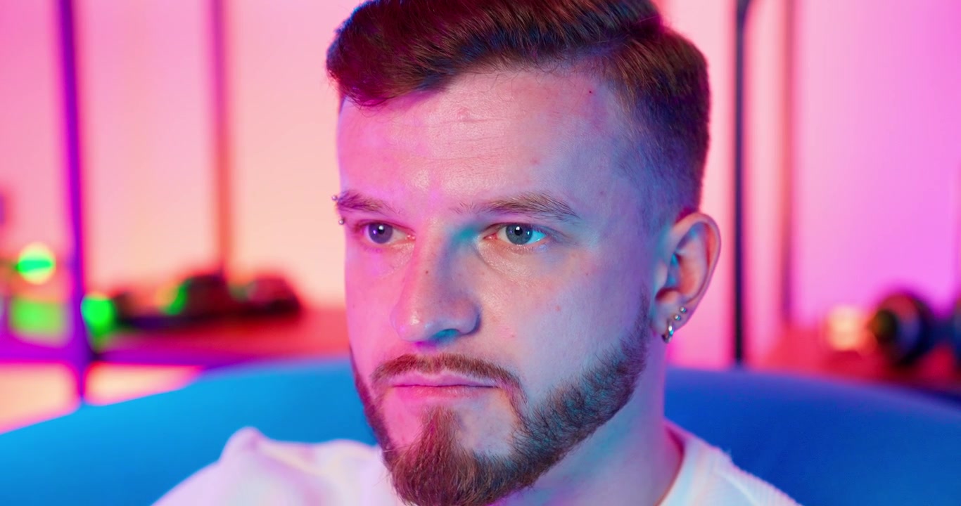 Primo piano di giovane uomo serio con illuminazione al neon vivace