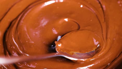 spoon stirring creamy chocolate in a bowl