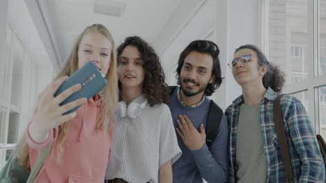 group of students taking a selfie in a university hallway
