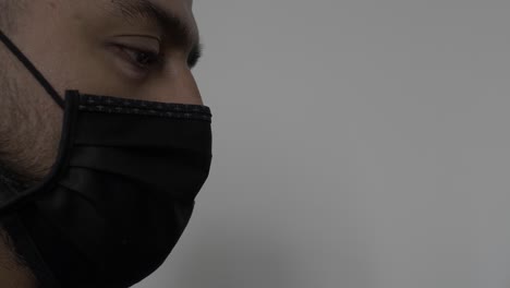 UK-Asian-Male-Wearing-Black-Face-Mask-Whilst-Looking-Downwards