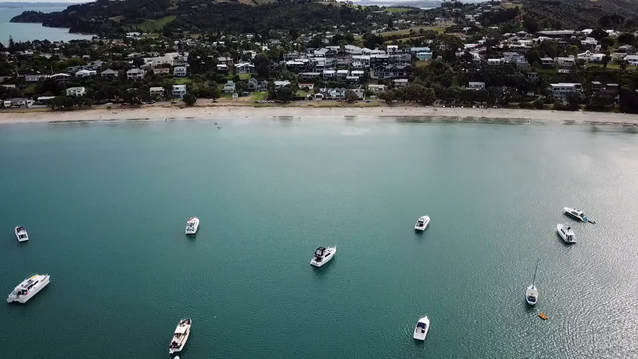 vista aérea de la ciudad, la playa y la bahía llena de barcos en la isla waiheke, nueva zelanda