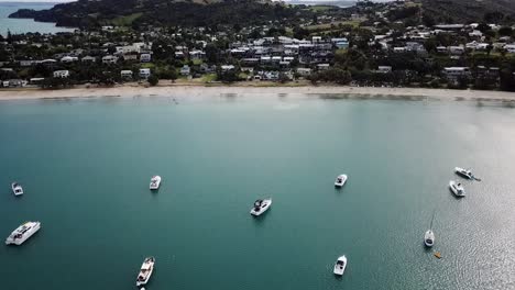 Vista-Aérea-De-La-Ciudad,-La-Playa-Y-La-Bahía-Llena-De-Barcos-En-La-Isla-Waiheke,-Nueva-Zelanda