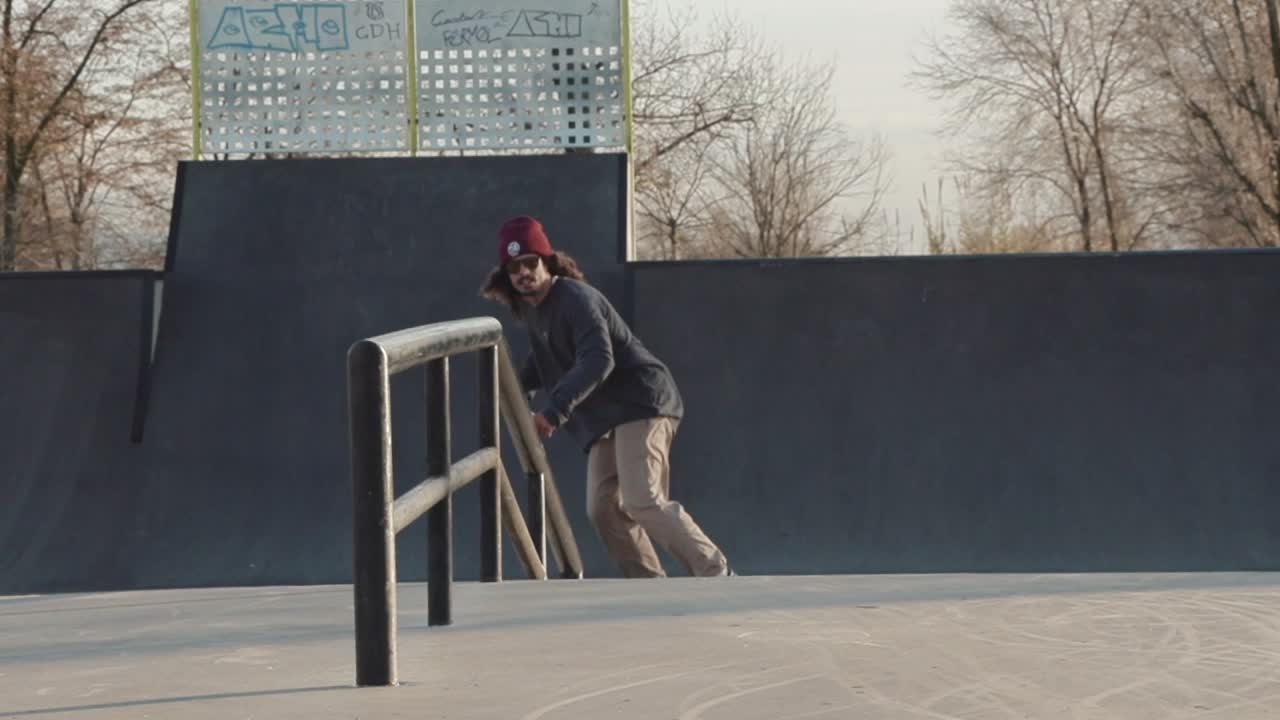 Close shot in slowmotion of a skateboarder doing a frontside board slide with rotation out on the last lights of the day.