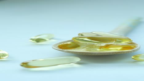 fish oil capsules in wooden spoon