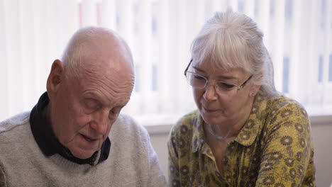 elderly couple enjoying a book together
