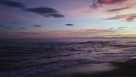 Dramatic-purple-sunset-at-the-beach-panning-to-the-right