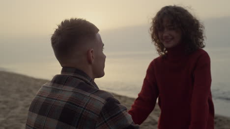 romantic couple kissing on beach at sunrise. woman and man looking at each other
