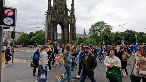 gente cruzando la calle cerca del monumento de scott