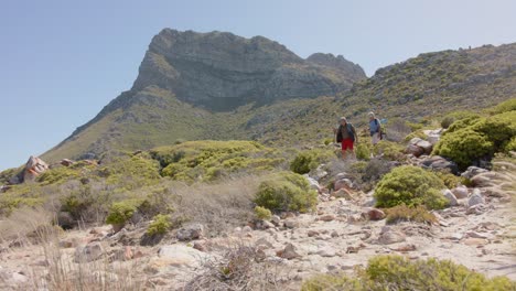 una feliz pareja biracial en las montañas haciendo senderismo, en cámara lenta