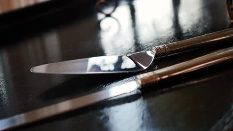 Polished-cake-knife-on-black-reflective-wedding-table