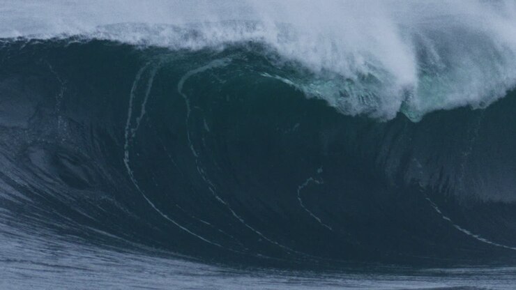 Telephoto slow motion closeup of strong ocean wave lip face rising crashing into glass water