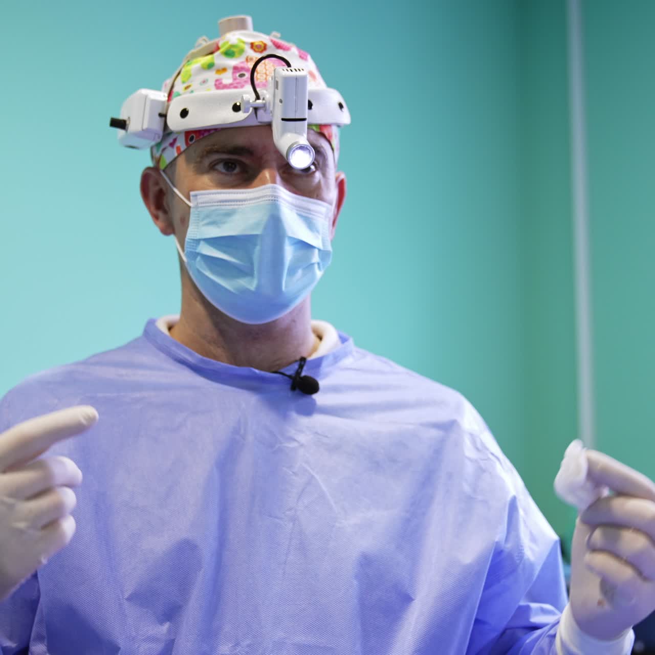 Mature male surgeon in a cap, mask and headlight. Portrait of a confident medical professional
