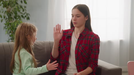 girl gives five to elder sister finishing eggs decorating