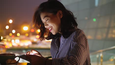 woman using tablet in cafe at night, 4k