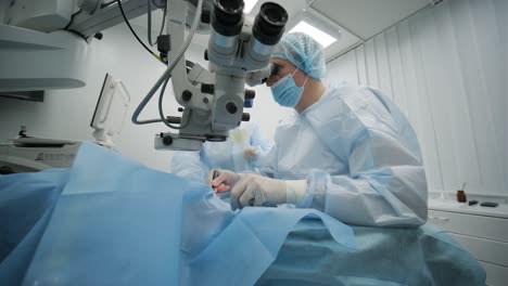 equipo de cirugía haciendo cirugía de estrabismo utilizando tecnologías modernas, dispositivos más recientes, microscopio en una clínica moderna