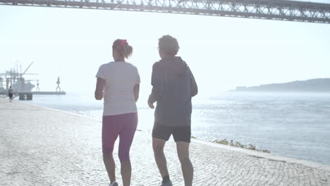 two sporty joggers running together and smiling