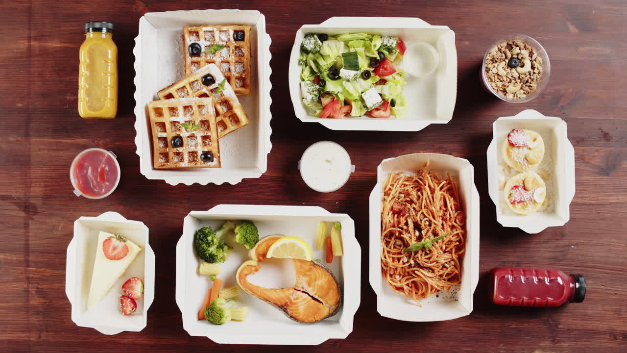 木製テーブルに置かれた様々なヘルシーなテイクアウト料理と飲み物の俯瞰図