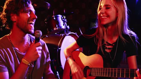 pareja tocando la guitarra y cantando una canción en un club nocturno 4k