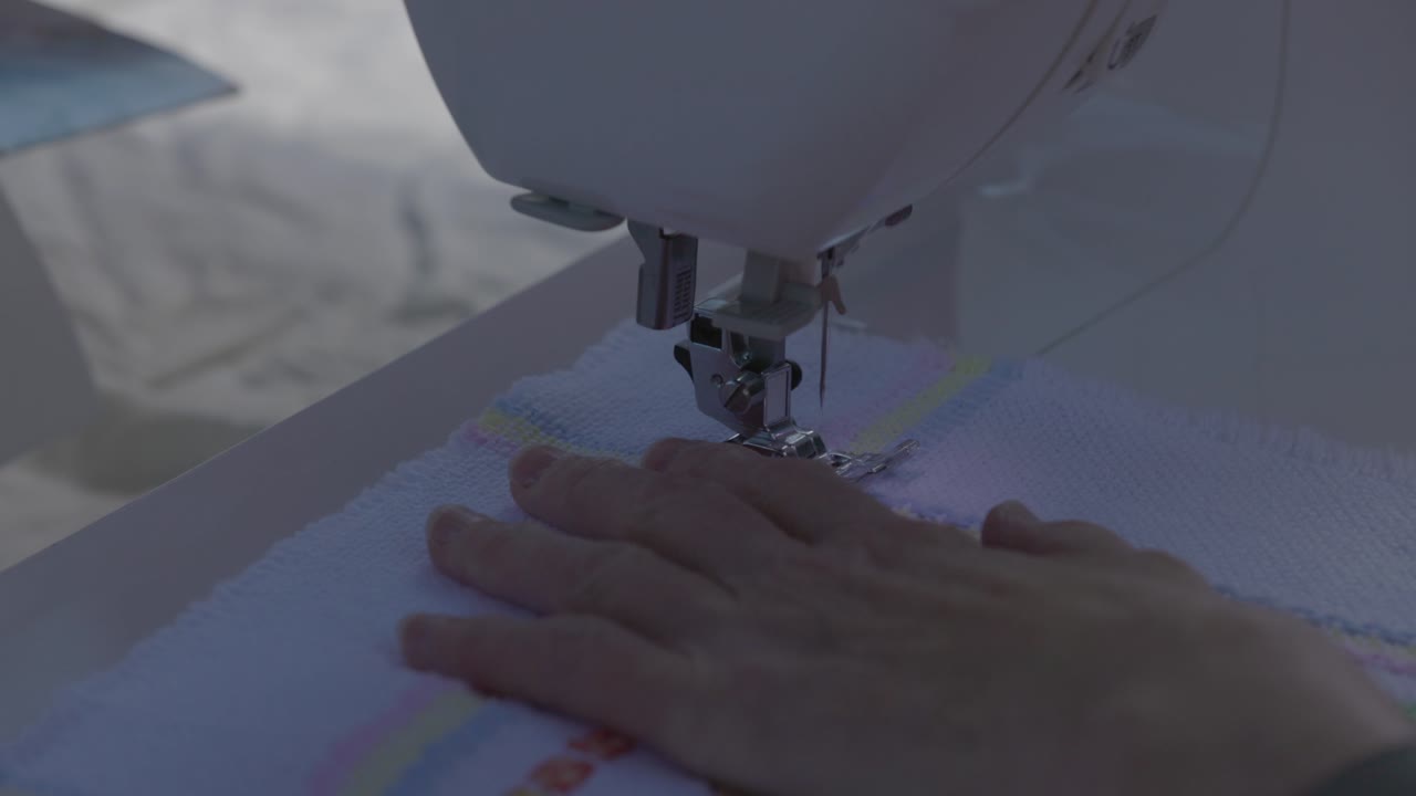 close-up shot of stitches being started to finish off a baby blanket