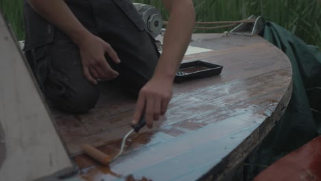 proa de cubierta de barnizado de barco de madera con rodillo