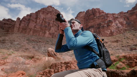 Adventure,-Photographer,-Travel,-Tourism,-Epic,-Passion,-Hobby,-Freedom---Man-taking-photo-of-the-grand-canyon-desert-landscape-in-the-Arizona-wilderness-with-his-backpack-and-dslr-camera-during-hike