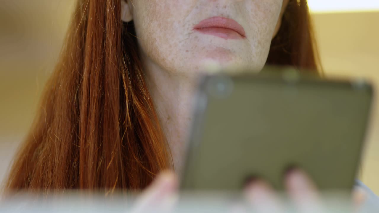 Woman holding tablet and initiating data scan, red lines crossing frame, numbers projecting on face