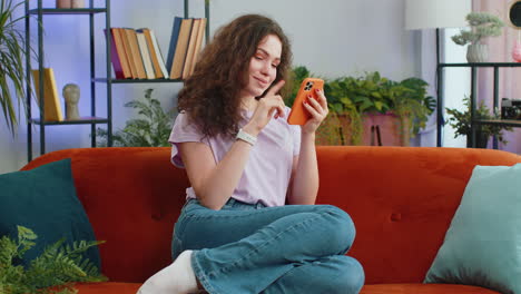 Woman-sitting-on-sofa-using-smartphone-share-messages-on-social-media-application-watching-movies