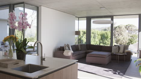 a modern living room with a large sectional sofa and vibrant flowers