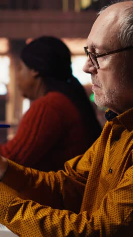 vertical video senior male student reading a book in a study area at a public library