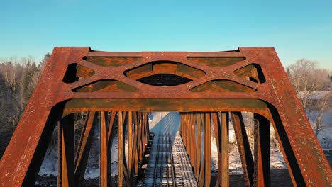 aerial crane down close up of a rusty railroad trestle on a cold winter morning